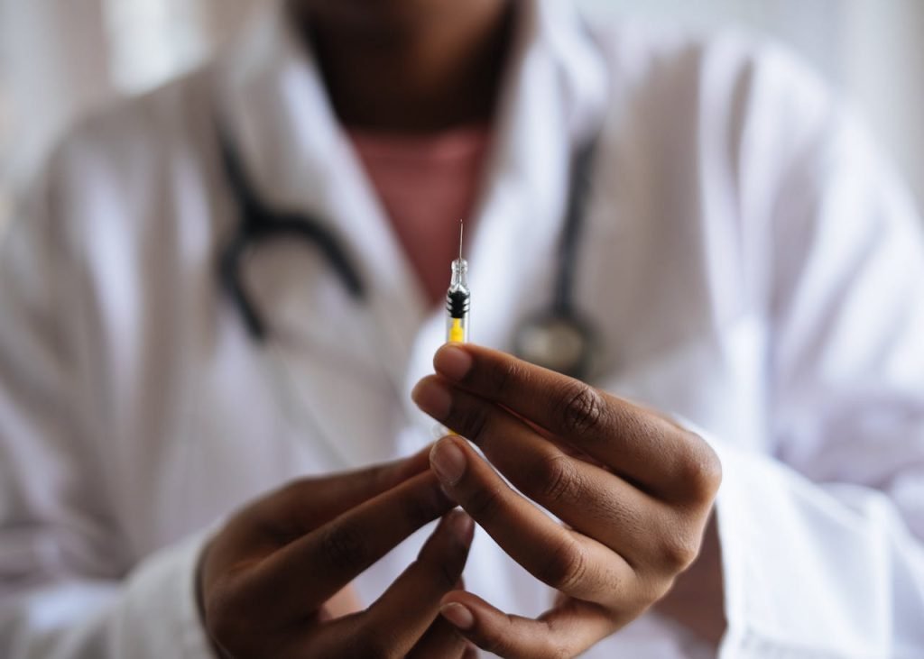 Close-up of a healthcare professional holding a syringe, symbolizing medical care and vaccination.